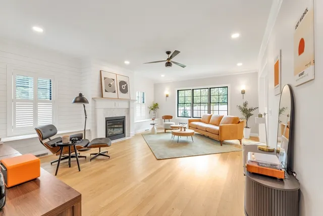 a living room with furniture fireplace and a large window