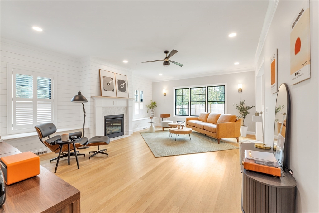 a living room with furniture fireplace and a large window