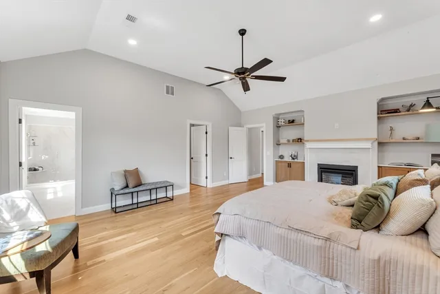 a bedroom with a bed chandelier and a view of kitchen