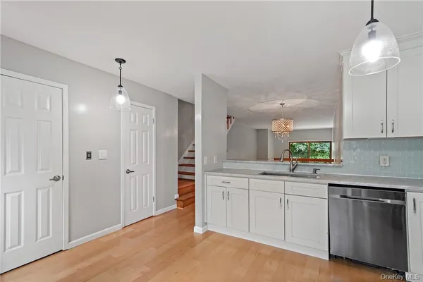 a kitchen with white cabinets and sink