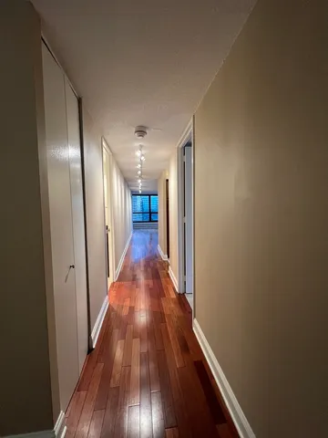 a view of a hallway with wooden floor
