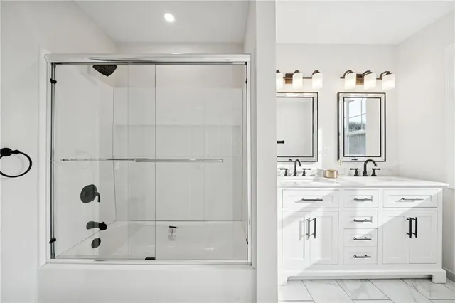 a bathroom with a double vanity sink mirror and shower