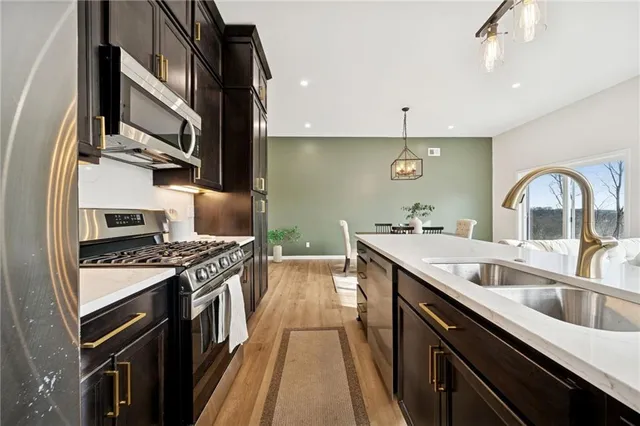 a kitchen with stainless steel appliances granite countertop a sink stove and cabinets