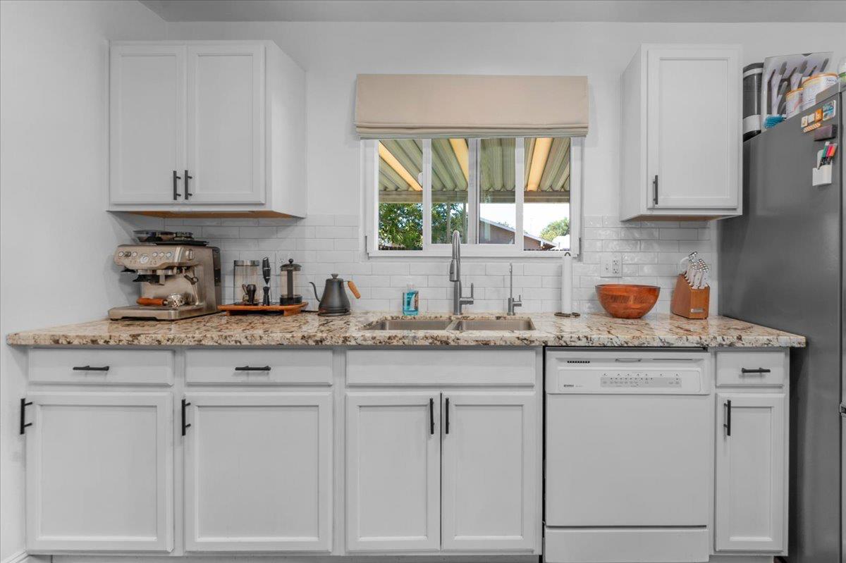 1448 Ashcroft Avenue Clovis, CA 93611 - Photo 12 of 46 a kitchen with granite countertop white cabinets and a window