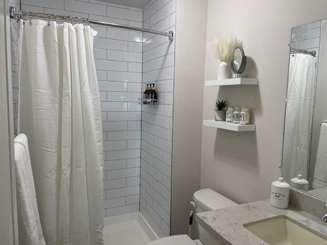 2202 Solo Street, Unit 2204 Houston, TX 77020 - Photo 16 of 21 Primary bathroom with floating shelves and a walk in shower and single vanity.