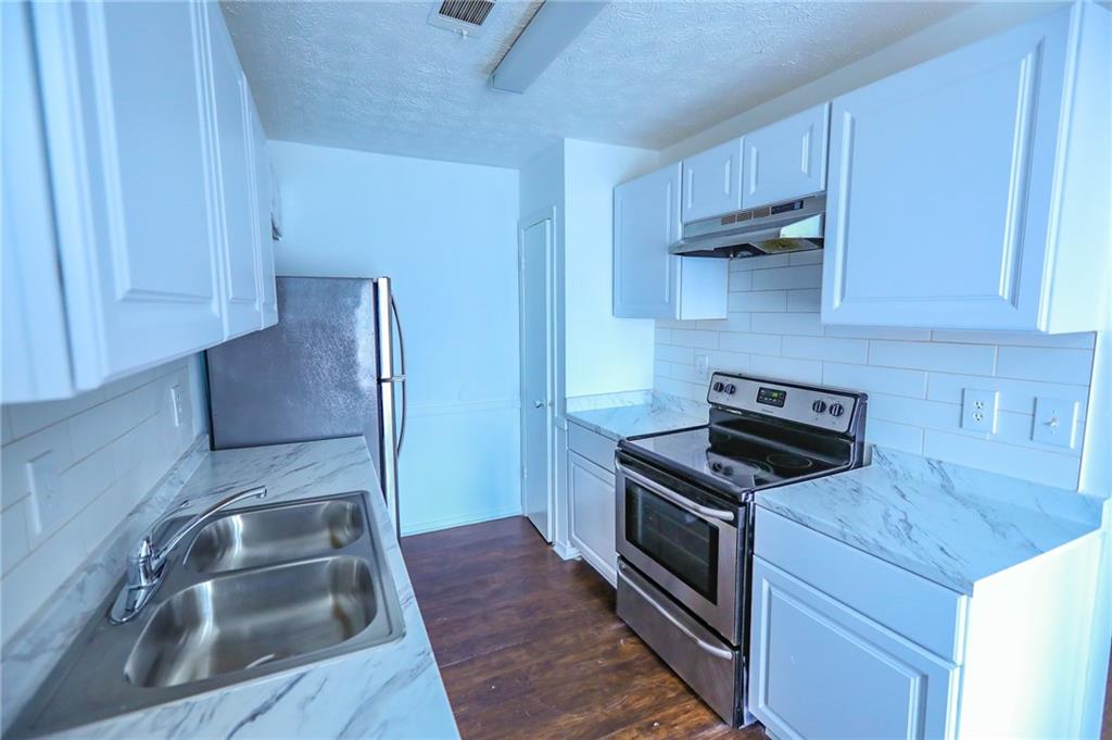 1967 Singer Way Lithonia, GA 30058 - Photo 2 of 28 a kitchen with granite countertop a sink stainless steel appliances and cabinets