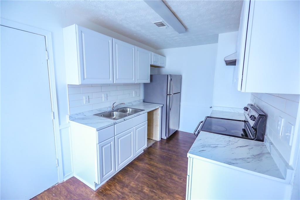 1967 Singer Way Lithonia, GA 30058 - Photo 7 of 28 a kitchen with a sink stove and cabinets