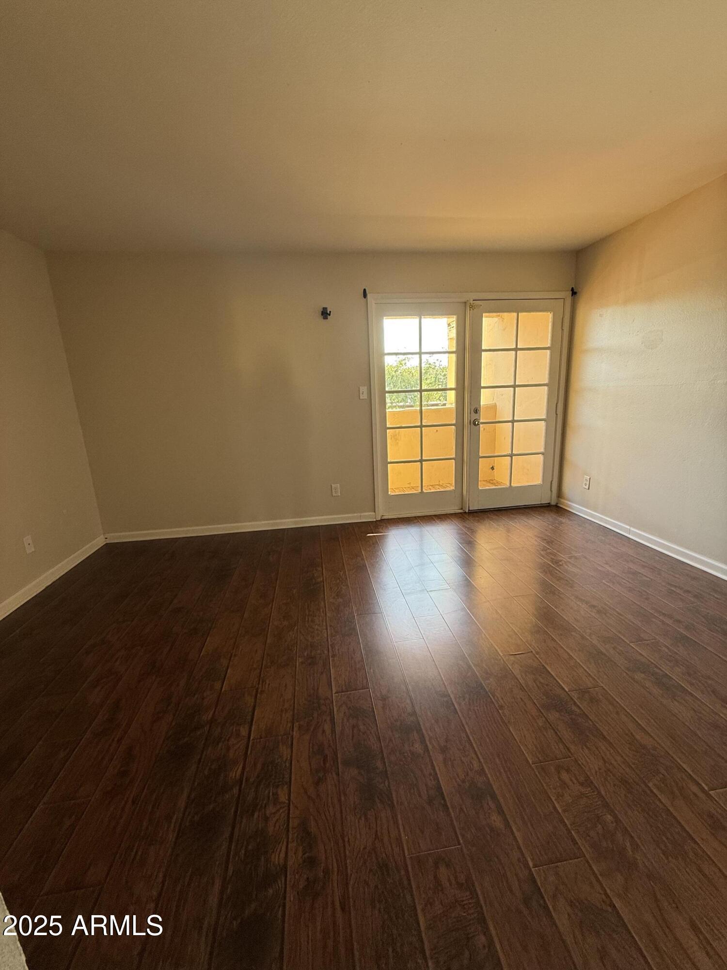 1425 East Desert Cove Avenue East, Unit 66 Phoenix, AZ 85020 - Photo 15 of 17 a view of an empty room with wooden floor and a window