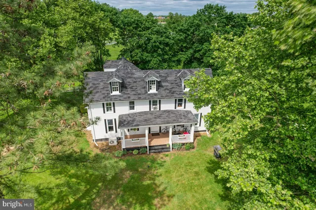 an aerial view of a house with a big yard plants and large trees