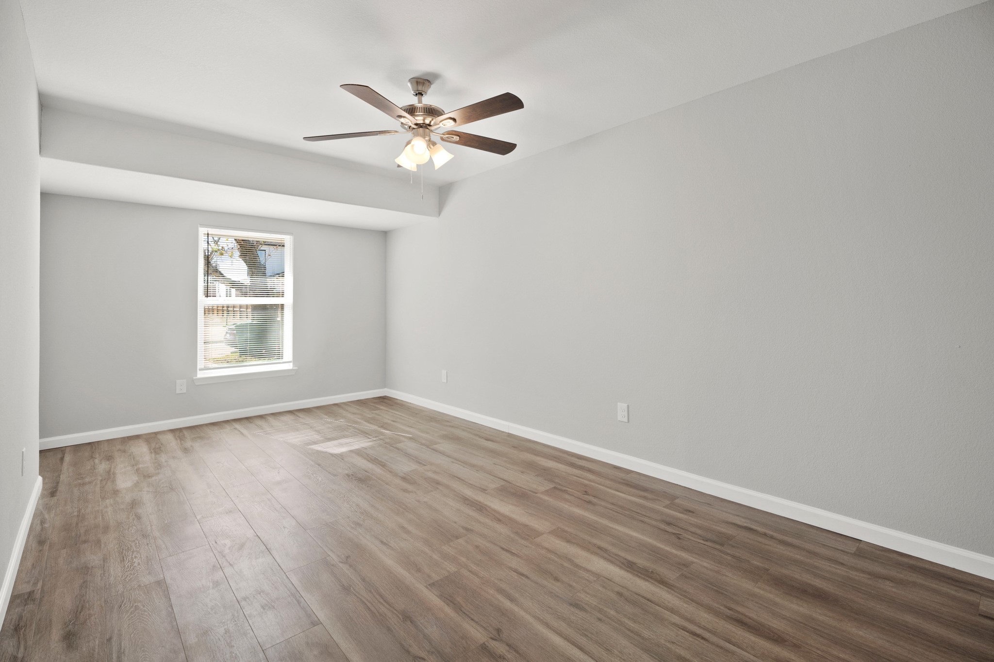 5123 Ridgeway Drive Houston, TX 77033 - Photo 8 of 21 Unwind after a long day in this incredible Primary Bedroom! Featuring vinyl plank floors, a ceiling fan, and neutral paint.