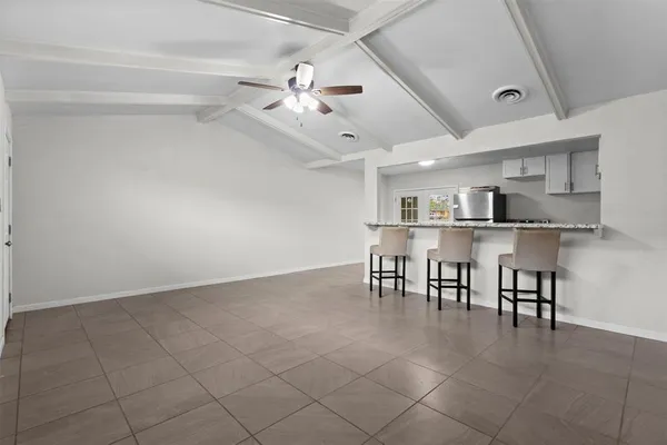 a view of a kitchen with refrigerator and white cabinets