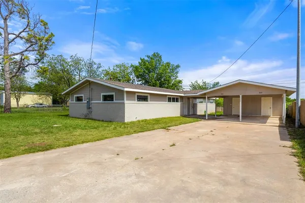 a front view of house with yard and trees around