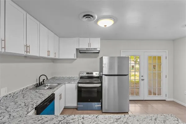 a kitchen with a refrigerator sink and cabinets