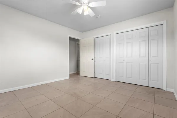 an empty room with fan and entrance