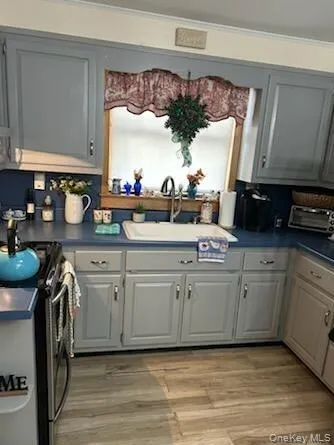 a white kitchen with a stove a sink and a refrigerator