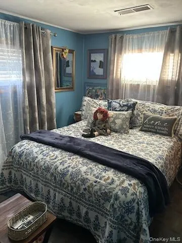 a bedroom with a bed window and a mirror