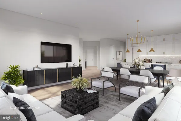 a living room with furniture a flat screen tv and kitchen view