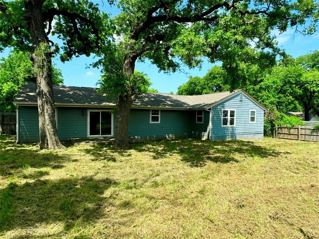 314 North Dubellette Street Weatherford, TX 76086 - Photo 21 of 30 a backyard of a house with large trees and wooden fence