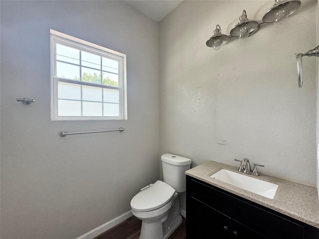314 North Dubellette Street Weatherford, TX 76086 - Photo 25 of 30 a bathroom with a granite countertop toilet and a sink