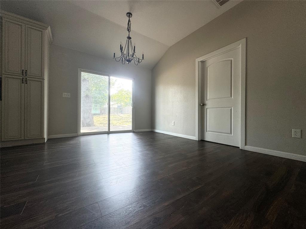 314 North Dubellette Street Weatherford, TX 76086 - Photo 7 of 30 an empty room with wooden floor chandelier and windows