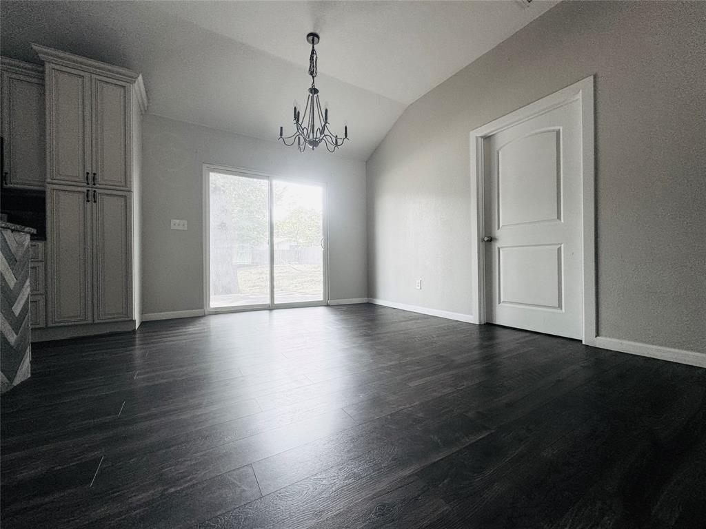 314 North Dubellette Street Weatherford, TX 76086 - Photo 9 of 30 an empty room with wooden floor chandelier and windows