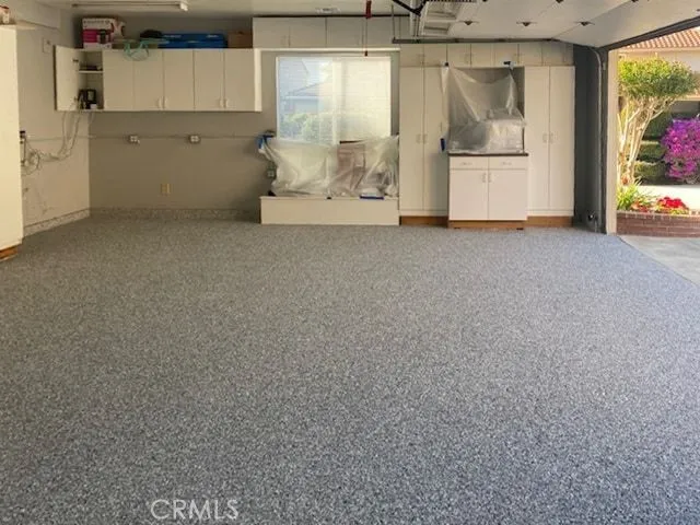 a view of a refrigerator in kitchen and white cabinets