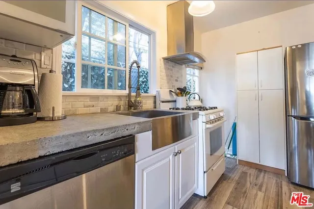 a kitchen with stainless steel appliances granite countertop a stove a refrigerator and a sink