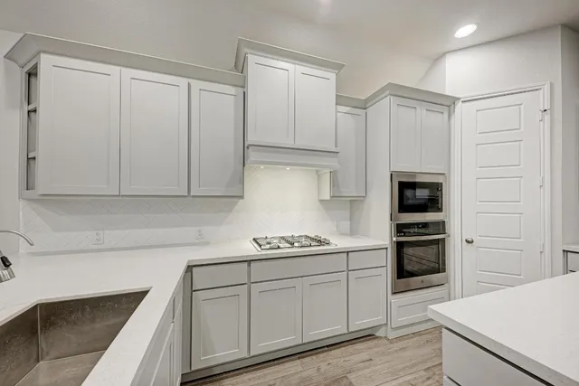 a kitchen with a sink a stove and cabinets