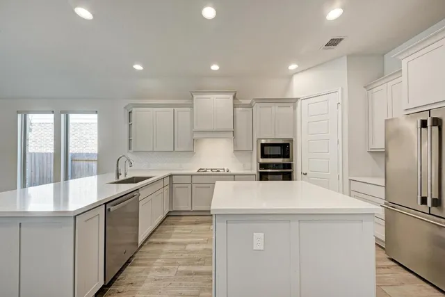 a kitchen with stainless steel appliances a refrigerator sink and stove