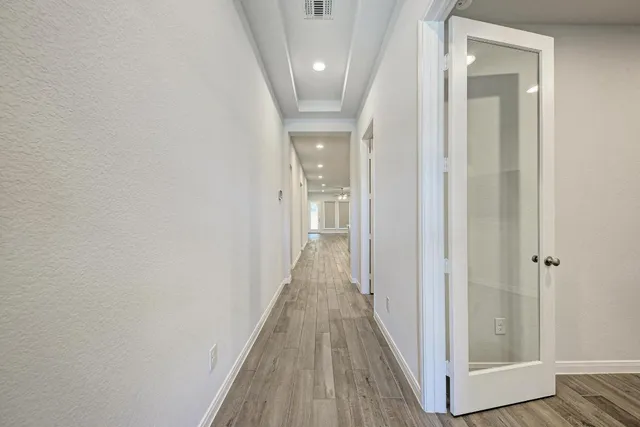 a view of a hallway with wooden floor and staircase