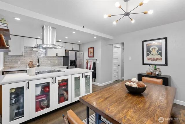 a kitchen that has a lot of cabinets a sink and wooden floor