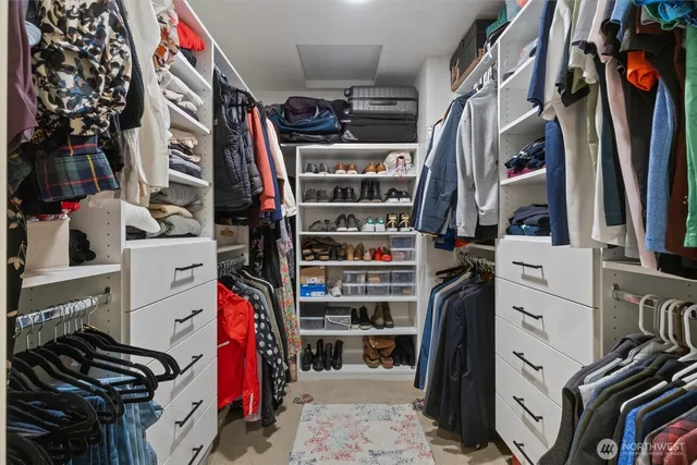 a view of walk in closet with clothes and shoes