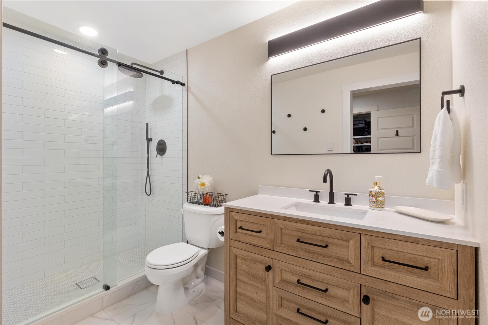 8515 Main Street, Unit 103 Edmonds, WA 98026 - Photo 21 of 34 a bathroom with a sink toilet vanity and shower