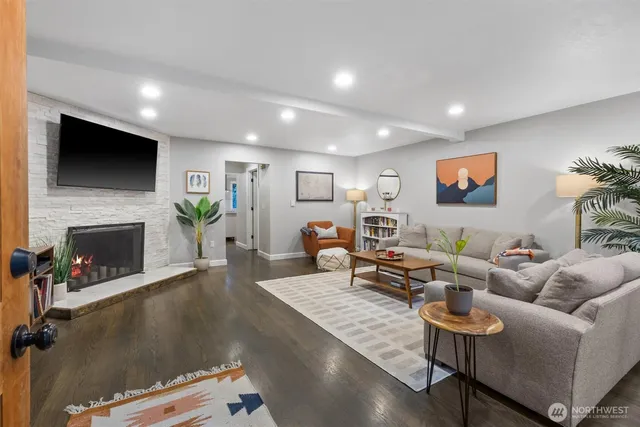 a living room with furniture a flat screen tv and a fireplace