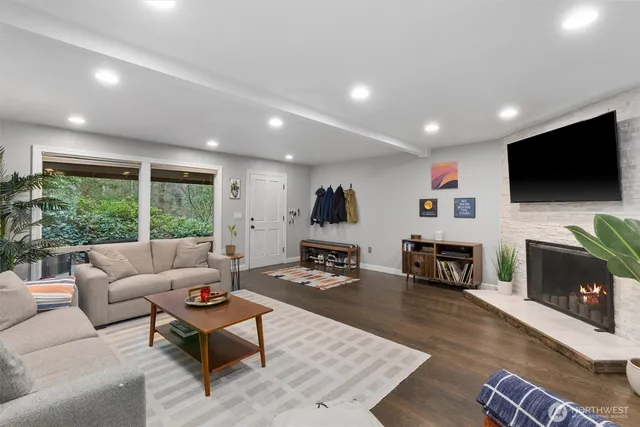 a living room with furniture a flat screen tv and a fireplace
