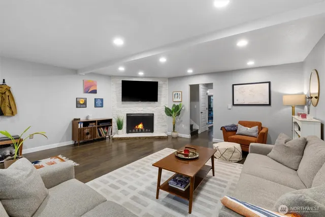a living room with furniture a fireplace and a flat screen tv