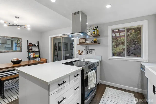 a kitchen that has a sink a stove and a wooden floor