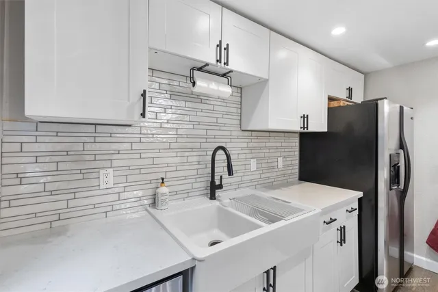 a kitchen with stainless steel appliances a sink dishwasher a refrigerator and a stove