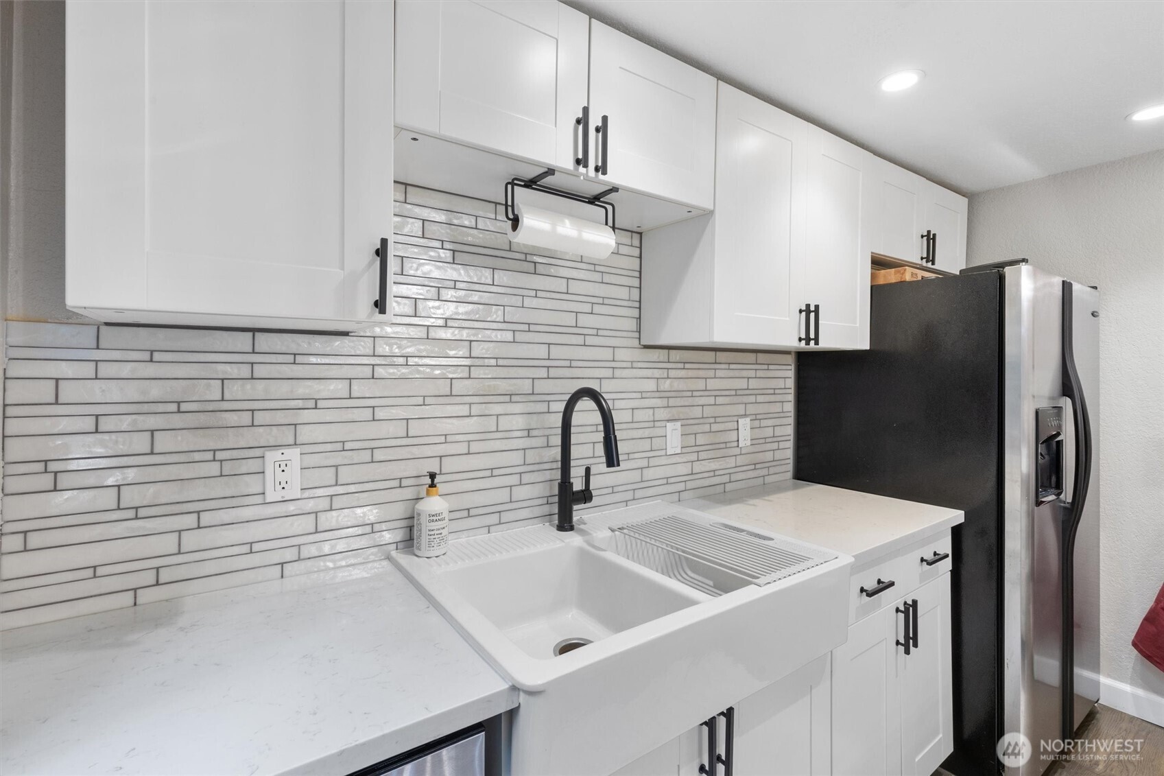 8515 Main Street, Unit 103 Edmonds, WA 98026 - Photo 10 of 34 a kitchen with stainless steel appliances a sink dishwasher a refrigerator and a stove