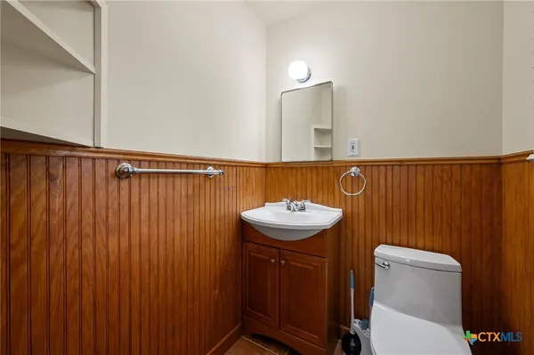 a bathroom with a sink a toilet and mirror