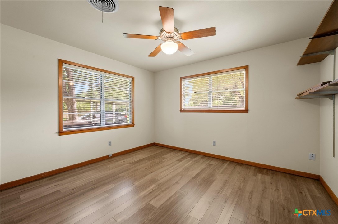 201 Hillcrest Drive Luling, TX 78648 - Photo 15 of 26 a view of an empty room with a window and a ceiling fan