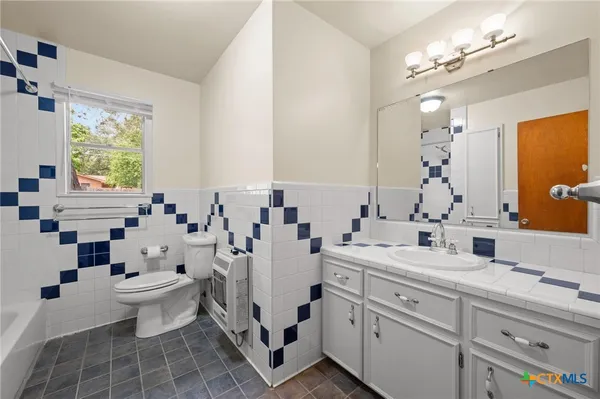 a view of bathroom with a toilet sink and mirror