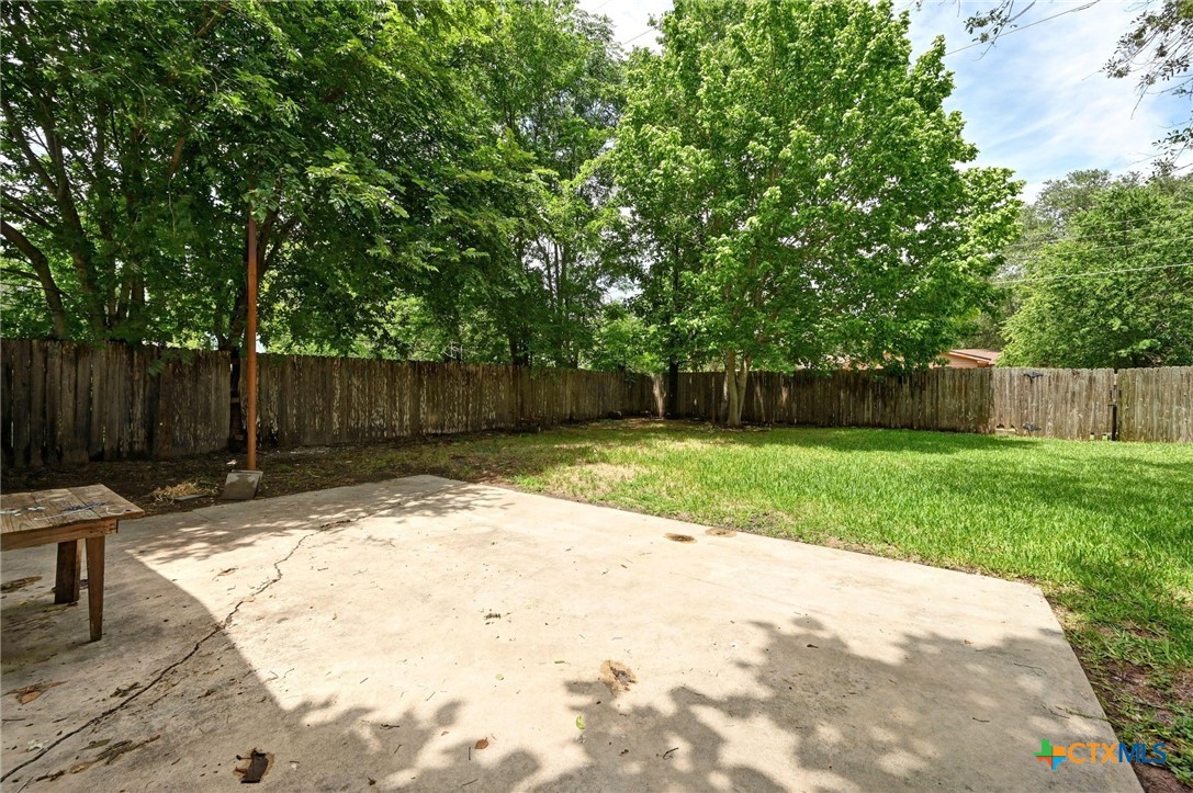 201 Hillcrest Drive Luling, TX 78648 - Photo 19 of 26 a view of a backyard with large trees and wooden fence