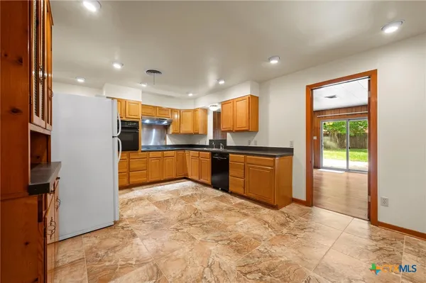 a kitchen with stainless steel appliances granite countertop a refrigerator and a sink
