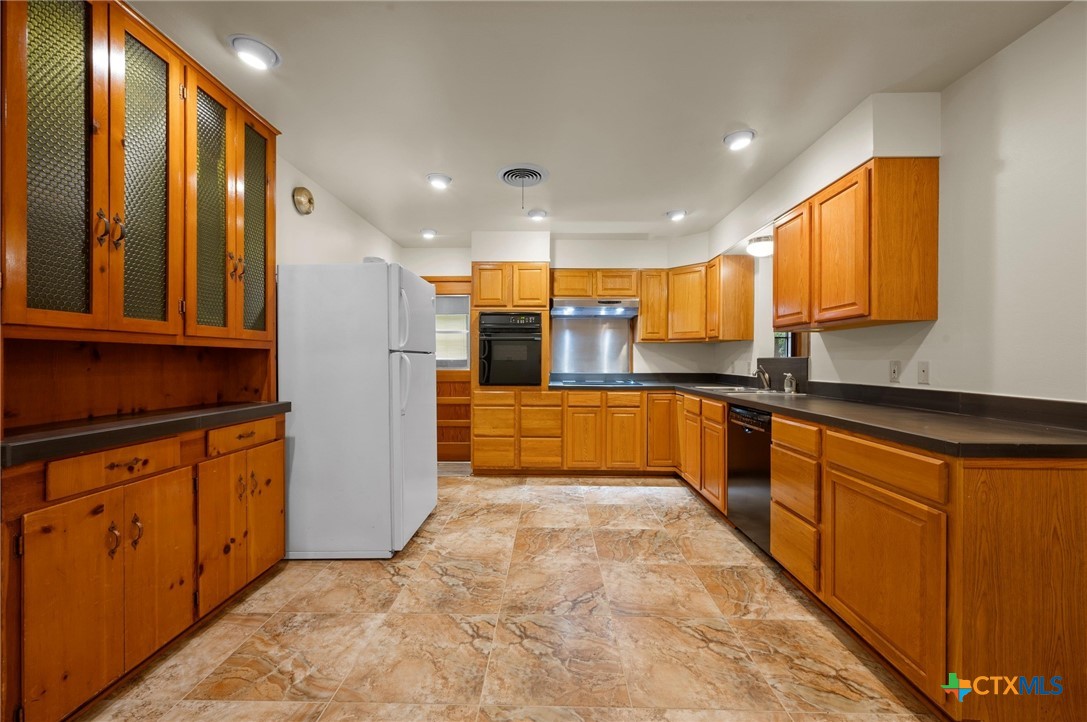 201 Hillcrest Drive Luling, TX 78648 - Photo 7 of 26 a large kitchen with stainless steel appliances granite countertop a large counter top stainless steel appliances and cabinets