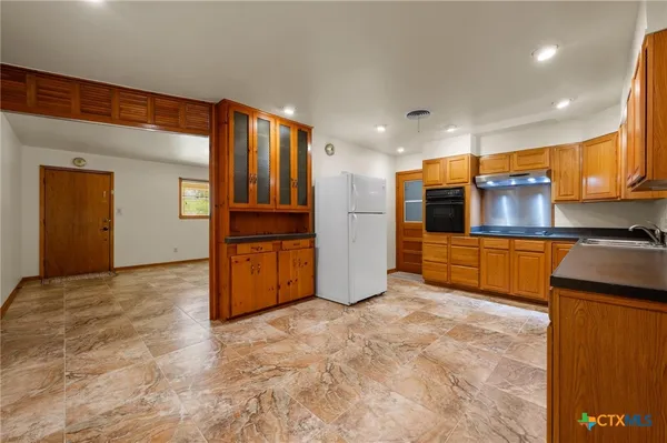 a view of kitchen with refrigerator and cabinets