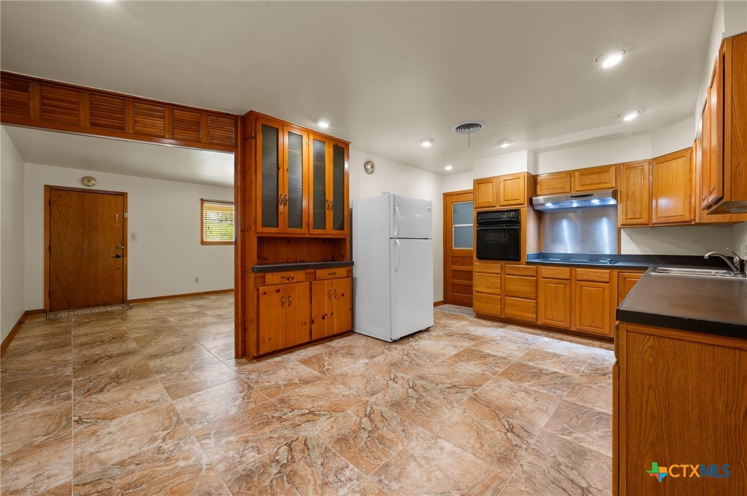 201 Hillcrest Drive Luling, TX 78648 - Photo 8 of 26 a view of kitchen with refrigerator and cabinets