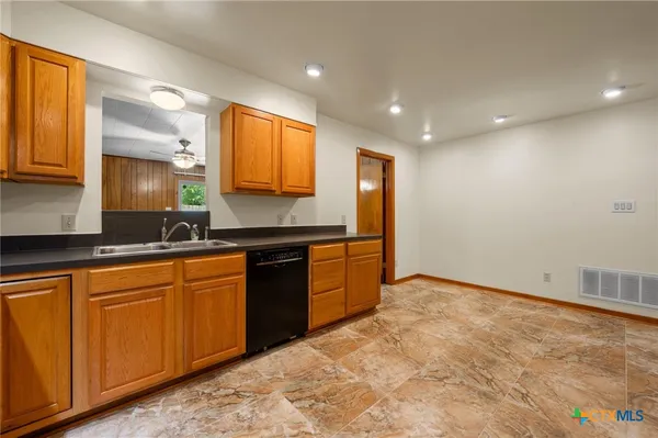 a large kitchen with stainless steel appliances granite countertop a sink and a stove