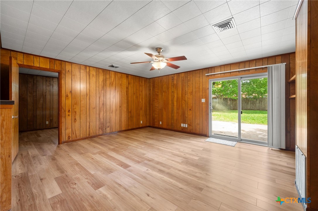 201 Hillcrest Drive Luling, TX 78648 - Photo 10 of 26 an empty room with windows a ceiling fan and wooden floor