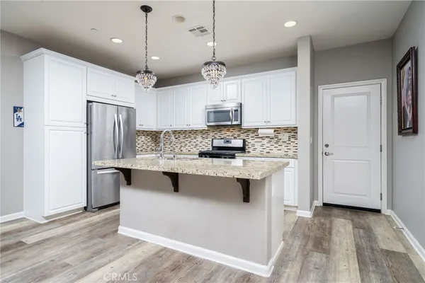 a kitchen with granite countertop a refrigerator stove and sink